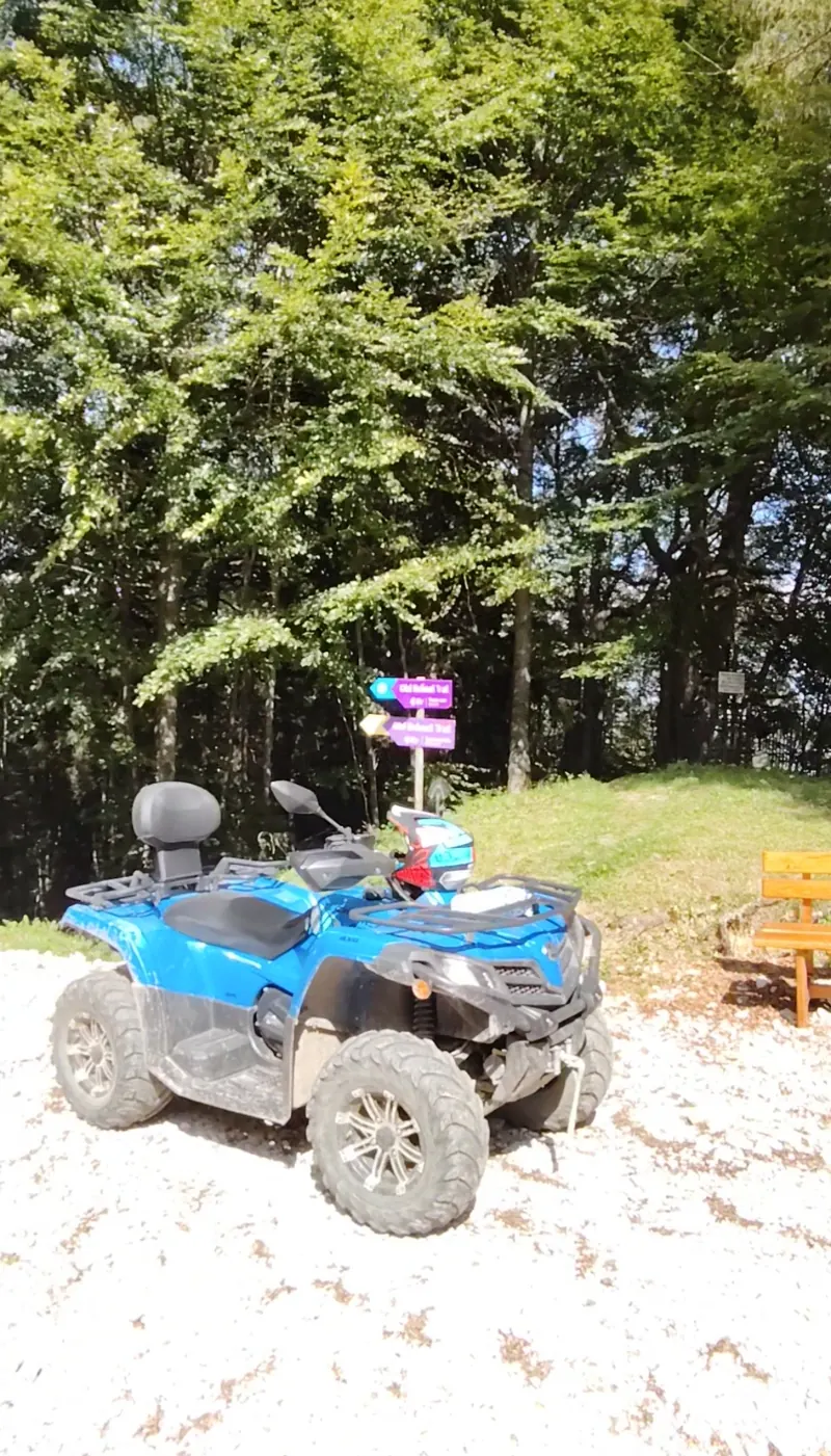 Blue ATV next to the trail signpost on Cota 1400, Bucegi Mountains