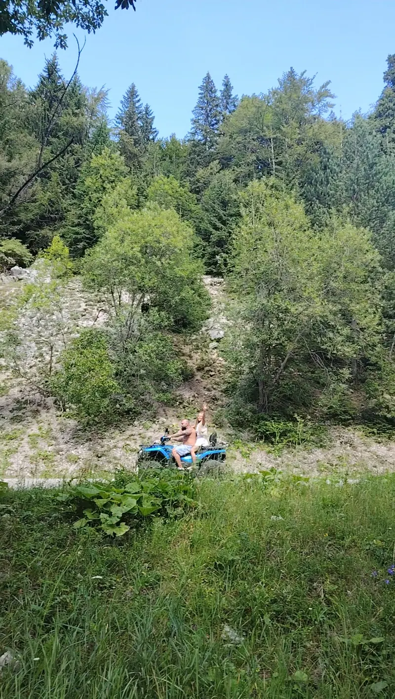 Blue ATV with tourists on the Cota 1400 trail, mountain adventure Sinaia