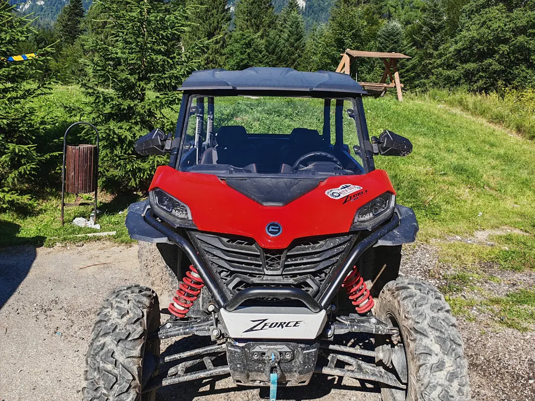 Red CFMOTO ZFORCE 950 Sport buggy with the Bucegi Mountains in the background