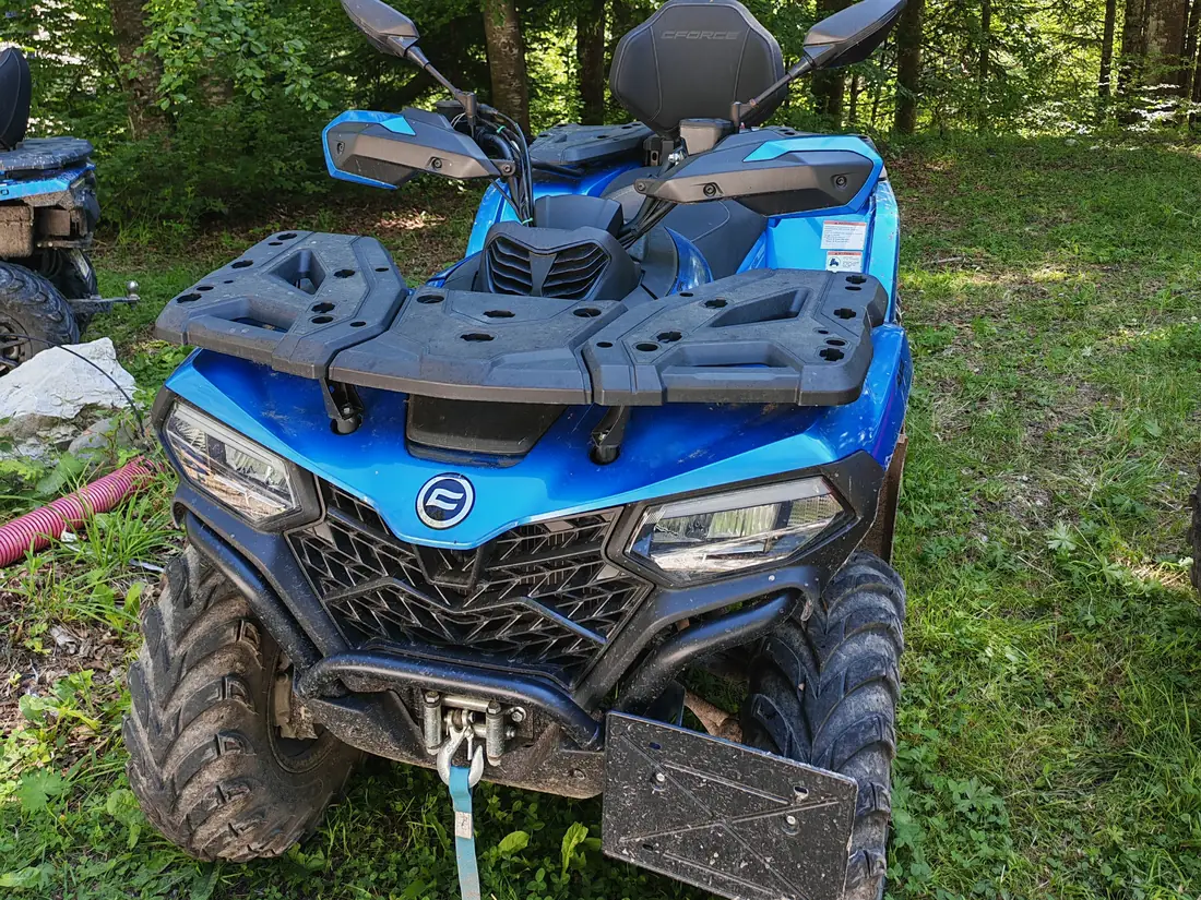 Blue CFMOTO CFORCE 520 L ATV in the forest of the Bucegi Mountains, Sinaia