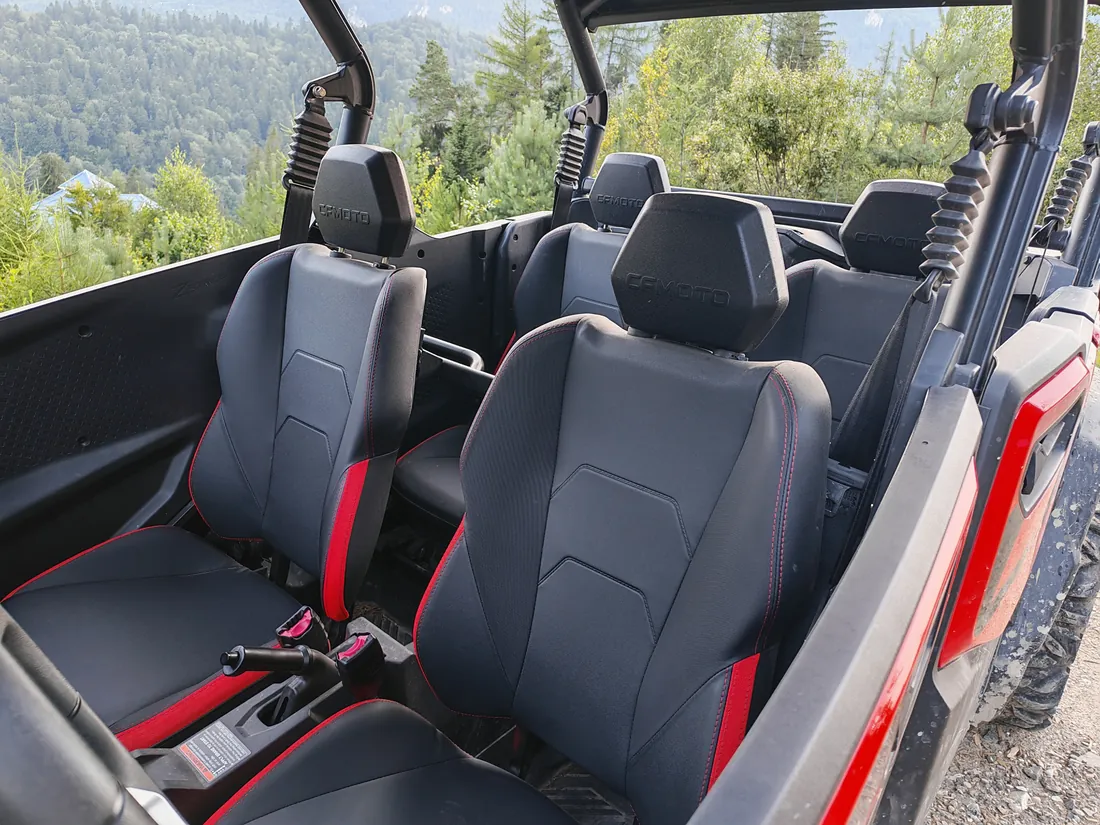 Interior of a CFMOTO buggy with seats and safety belts, ready for a tour in the Bucegi Mountains